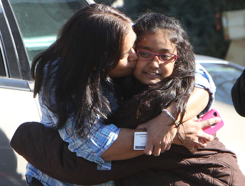 A woman hugs her daughter after being reunited at the Sandy Hook firehouse after a mass shooting at the Sandy Hook Elementary School in Newtown, Conn. on Friday, Dec. 14, 2012. (AP Photo/The Journal News, Frank Becerra Jr.)