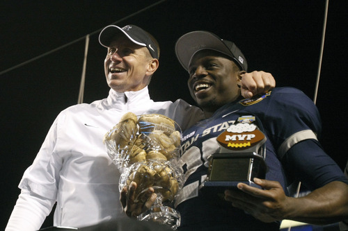 Chris Detrick  |  The Salt Lake Tribune
Utah State Aggies head coach Gary Andersen and Utah State Aggies running back Kerwynn Williams (25) pose for pictures with the trophy after winning the Famous Idaho Potato Bowl at Bronco Stadium Saturday December 15, 2012.  The Aggies beat the Rockets, 41-15.