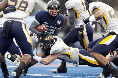 Chris Detrick  |  The Salt Lake Tribune
Utah State Aggies kicker Nick Diaz (93) is tackled by Toledo Rockets linebacker Chase Murdock (34) during the second quarter of the Famous Idaho Potato Bowl at Bronco Stadium Saturday December 15, 2012.  At the end of the first half the Aggies were winning, 10-6.
