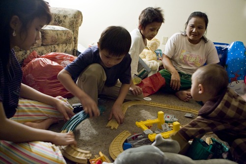 Keith Johnson |  The Salt Lake Tribune
Burmese refugee Mu Paw, top right, and her children Mu Kbaw, 14, left; Sunnay Bra, 10; Ehta Kpaw Say, 8; and her grandson Thyu Htoo, 18 months, play with Christmas toys they received from representatives of Catholic Community Services at their home in South Salt Lake December 12, 2012. Mu Paw and her family arrived in Utah only a month ago.