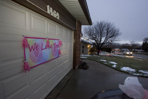 Paul Fraughton  |   Salt Lake Tribune
Family, friends and neighbors of the Parker family  spread out over their Ogden neighborhood Monday night  hanging pink ribbons  to commemorate  young Emilie Parker, who was one of the children killed in the shooting at the Connecticut  elementary school. A sign hangs on the garage door of Randy Parker, Emilie's grandfather expressing the feelings of the community.
 Monday, December 17, 2012