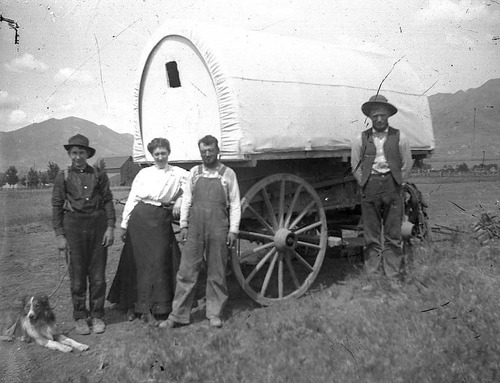 (Photo Courtesy Utah State Historical Society)

Three men, a woman and their dog next to their covered wagon in 1878.