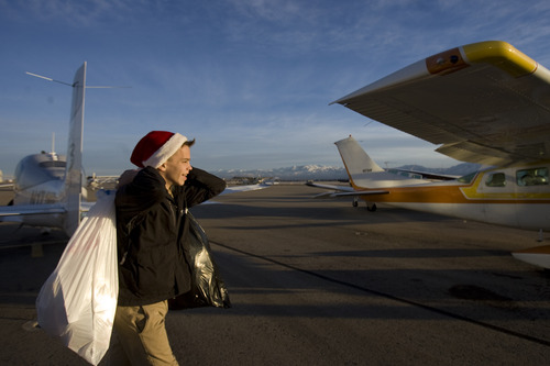 Kim Raff  |  The Salt Lake Tribune
Eagle Scout James Pembroke carries donated supplies to a plane to be loaded for the Santa Flight at the South Valley Regional Airport on Thursday, Dec. 20, 2012. Twelve pilots joined by Santa and Mrs. Claus flew planes, filled with donated supplies for students at Monroe Elementary, to Richfield Airport from South Valley Regional Airport in West Jordan.