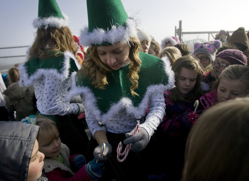 Kim Raff  |  The Salt Lake Tribune
Elves (back) Sierra and Brooklyn Bollinger hand out candy canes to children from Monroe Elementary at Richfield Municipal Airport after flying in with donated supplies for the school on Thursday, Dec. 20, 2012. Twelve pilots joined by Santa and Mrs. Claus flew planes, filled with donated supplies for students at Monroe Elementary, to Richfield Airport from South Valley Regional Airport in West Jordan.