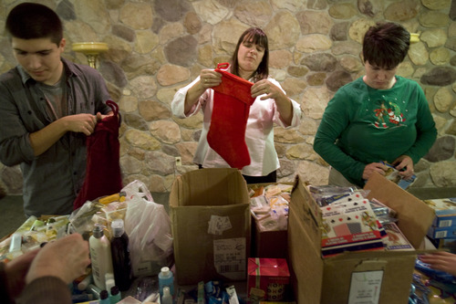 Kim Raff  |  The Salt Lake Tribune
Chrystal Butterfield stuffs stockings for soldiers with her (left) Braxton and (right)  Brandy Burningham during a volunteer work day for the Stockings for Soldiers program at Redwood Cemetery in Taylorsville on November 29, 2012. Butterfield is a very active volunteer, on top of working full-time and raising three kids.