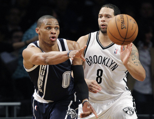 Oklahoma City Thunder guard Russell Westbrook (0) passes as Brooklyn Nets guard Deron Williams (8) defends in the first half of their NBA basketball game at Barclays Center, Tuesday, Dec. 4, 2012, in New York. (AP Photo/Kathy Willens)