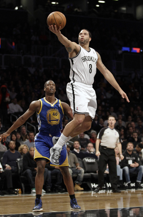 Golden State Warriors forward Harrison Barnes (40) watches from the floor as Brooklyn Nets guard Deron Williams (8) goes up for a layup in the first half of an NBA basketball game at Barclays Center, Friday, Dec. 7, 2012, in New York. (AP Photo/Kathy Willens)