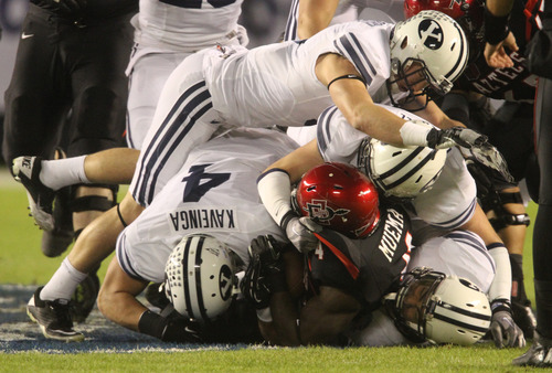 Rick Egan  | The Salt Lake Tribune 

It takes four Brigham Young Cougars to bring down San Diego State Aztecs running back Adam Muema (4) in football action during the Poinsettia Bowl, BYU vs. San Diego State, Thursday, December 20, 2012.