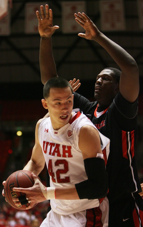 Kim Raff  |  The Salt Lake Tribune
University of Utah center Jason Washburn (42) tries to drive the basket as he is defended by (right) Cal State Northridge center Brandon Perry (32) during a game at the Huntsman Center in Salt Lake City on December 21, 2012.