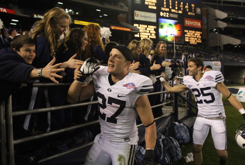 Rick Egan  | The Salt Lake Tribune 

Brigham Young Cougars running back David Foote (27) and Brigham Young Cougars wide receiver Kurt Henderson (25) shake hands with BYU fans after BYU defeated San Diego State 23-6 in the Poinsettia Bowl, Thursday, December 20, 2012.