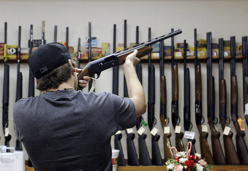 In this photo taken Wednesday, Dec. 19, 2012, a customer checks out a shotgun at Burdett & Son Outdoor Adventure Shop in College Station, Texas. More civilians are armed in the U.S. than anywhere else in the world, with Yemen coming in a distant second, according to the Small Arms Survey in Geneva. (AP Photo/Pat Sullivan)