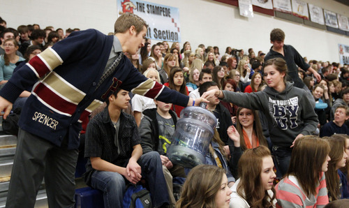 Al Hartmann  |  The Salt Lake Tribune
Spencer Jones, spirit officer, left, passes money donation jug through students at Herriman High School Hearts of Gold closing assembly on Friday December 21.   The assembly celebrated the season charity drive with everything from a dodge ball championship match to dances and student body skits. Through prior student donations and today's assembly the school raised $30,012,56 for charity.