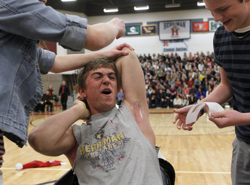 Al Hartmann  |  The Salt Lake Tribune
Colton  Lindquist, Junior Student Body President screams as he gets his armpits waxed at Herriman High School Hearts of Gold closing assembly on Friday December 21.   The assembly celebrated the season charity drive with everything from a dodge ball championship match to dances and student body skits. Through prior student donations and today's assembly the school raised $30,012,56 for charity.