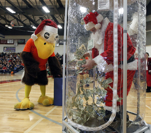 Al Hartmann  |  The Salt Lake Tribune
Brent Cox, digital media teacher grabs floating money in an enclosure full of money from Mountain America Credit Union to donate to charity at Herriman High School Hearts of Gold closing assembly on Friday December 21.   The assembly celebrated the season charity drive with everything from a dodge ball championship match to dances and student body skits. Through prior student donations and today's assembly the school raised $30,012,56 for charity.