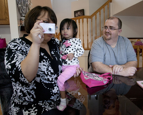 Steve Griffin | The Salt Lake Tribune

Miriam Jensen, 20-months, plays with her parents, Farah and Jhan Jensen, in their Roy home Monday December 24, 2012. The couple have been trying to adopt Miriam from Malaysia since she was born. But through a pile of red tape and difficulties, they've never been able to bring her back to Utah. Until now. She arrived last week and will spend Christmas with her parents. According to the State Department, there have only been 16 successful adoptions from Malaysia between 1999 and 2011.