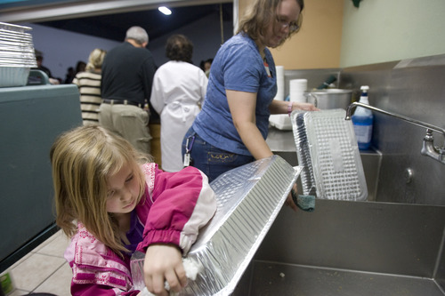 Kim Raff  |  The Salt Lake Tribune
(left)Volunteers Isabelle Hamilton dries dishes as her mother, Karen Hamilton, washes them during the Salt Lake City Mission's Christmas day meal at the Christian Life Center in Salt Lake City on December 25, 2012. The Hamilton family drives down from Rupert, ID to volunteer for this dinner every year.