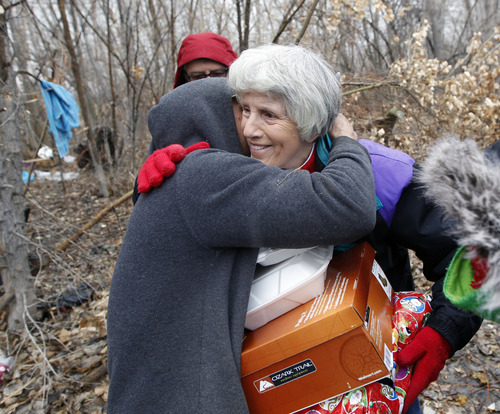 Al Hartmann  |  The Salt Lake Tribune
Homeless advocate Pamela Atkinson gets a hug and thanks from "Scott" a homeless man who lives in a camp along the Jordan River after giving him a hot meal, boots and a warm coat Monday December 24.  Atkinson and friend Ed Snoddy, medical outreach coordinator for Volunteers of America visited homeless people around Salt Lake City offering hot meals, boots, and warm clothing to help get them through the cold weather.