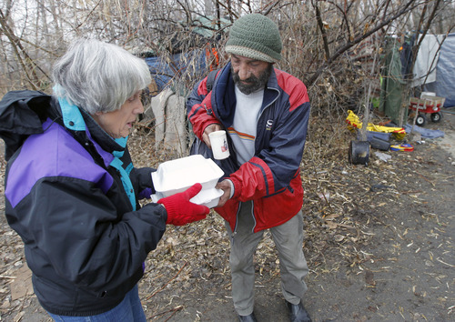 Al Hartmann  |  The Salt Lake Tribune
Homeless advocate Pamela Atkinson delivers a hot meal to "Ali" a homeless man who lives in a tent along the Jordan River Monday December 24.  Atkinson and friend Ed Snoddy, medical outreach coordinator for Volunteers of America visited homeless people around Salt Lake City offering hot meals, boots, and warm clothing to help get them through the cold weather.