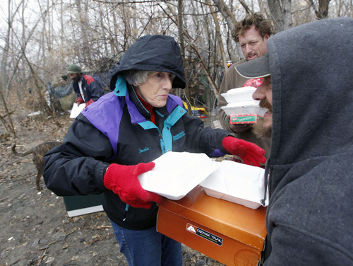 Al Hartmann  |  The Salt Lake Tribune
Homeless advocate Pamela Atkinson delivers a hot meal, boots and a warm coat to to "Scott" a homeless man who lives in a camp along the Jordan River Monday December 24.  Atkinson and friend Ed Snoddy, medical outreach coordinator for Volunteers of America visited homeless people around Salt Lake City offering hot meals, boots, and warm clothing to help get them through the cold weather.