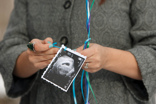 Trent Nelson  |  The Salt Lake Tribune
Stephanie Cook attaches a sonogram of the baby she's expecting to balloons she released to mark the day her mother, Bobbi Campbell, disappeared 18 years ago. Thursday December 27, 2012 in Cottonwood Heights. On the back of the sonogram was a note to Campbell telling her she's, "going to be a grandma this year."