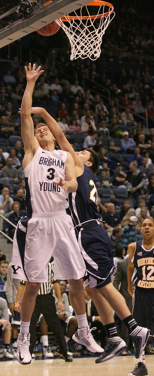 Paul Fraughton  |   Salt Lake Tribune
 After the shot BYU's Tyler Haws takes an arm to the head from NAU's Stallon Saldivar. BYU played Northern Arizona University at The Marriott Center in Provo.
 Thursday, December 27, 2012