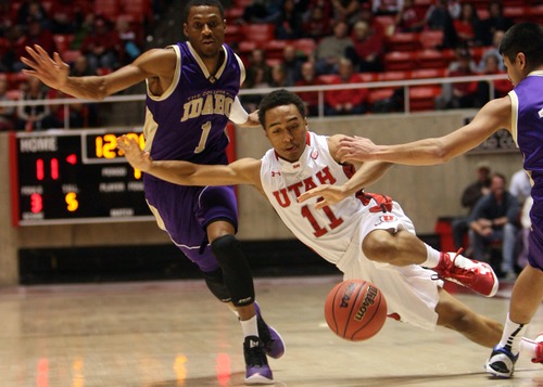 Kim Raff  |  The Salt Lake Tribune
University of Utah guard Brandon Taylor (11) is tripped up while dribbling the ball down the court past College of Idaho player Rodney Delgardo during a game at the Huntsman Center in Salt Lake City on December 28, 2012.