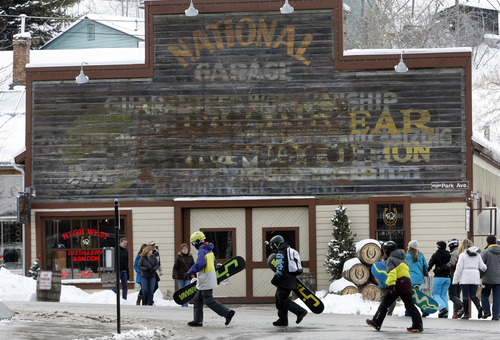 Rick Egan  | The Salt Lake Tribune
Snowboarders cross the street near Main Street in Park CIty on Friday.