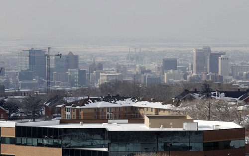 Al Hartmann  |  The Salt Lake Tribune
Building in upper Research Park basks in weak sunlight as downtown Salt Lake City several hundred feet below is mired in cold smoggy air.  The temperature inversion is due to increase in the next few days.