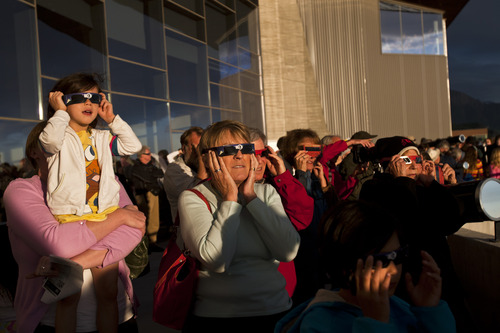 Chris Detrick  |  The Salt Lake Tribune
Rebecca Le holds up her daughter Helen Le, 5, as Mindy Ramsey and other visitors watch the transit of Venus at the Natural History Museum of Utah Tuesday June 5, 2012. The last time such an event was viewable from Utah was 1882; it won't be seen again from the Beehive State until 2125, decades after even Halley's Comet will have come and gone again.