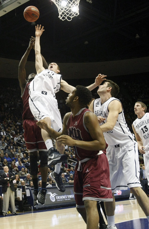Chris Detrick  |  The Salt Lake Tribune
Brigham Young Cougars forward Josh Sharp (12) and Loyola Marymount Lions forward Ashley Hamilton (5) go up for a rebound during the first half of the game at  Thursday January 3, 2013.  BYU is winning the game 35-20.