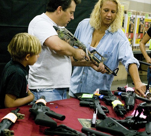 Djamila Grossman  |  The Salt Lake Tribune

Keith and Sherri Brown look at rifles for their son, Dustin Brown, 9, left, at the Rocky Mountain Gun Show in the South Towne Expo Center in Sandy, Utah, on Saturday, Aug. 13, 2011.
