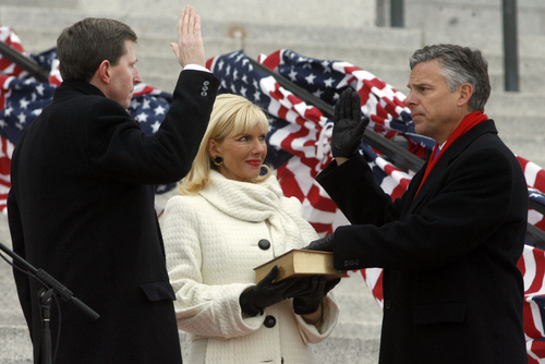 Salt Lake City - With his wife Mary Kaye Huntsman holding The Bible Utah governor Jon Huntsman (right) takes the oath of office from Utah Supreme Court associate chief justice Matthew B. Durrant, on the steps of the state capitol in Salt Lake City Monday  January 5, 2009.  Steve  Griffin/The Salt Lake Tribune 1/5/09