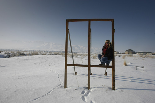 Rick Egan  | The Salt Lake Tribune 

Barbie Riccardelli sits in the frame that used to be a sign advertising single-family lots near her home in Saratoga Springs, Thursday, Jan. 3, 2013. Riccardelli and other residents in Saratoga Springs are suing the city and have a referendum to stop development of high-density rental homes in their neighborhood, near the golf course.