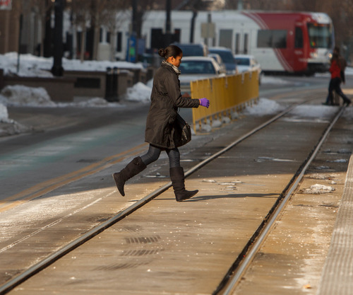 Trent Nelson  |  The Salt Lake Tribune
A woman hurries to cross TRAX lines without regard to the crosswalk or the train approaching in the background in downtown Salt Lake City. A recent observation session by a Tribune reporter indicates hundreds of violations daily around TRAX stations and lines.