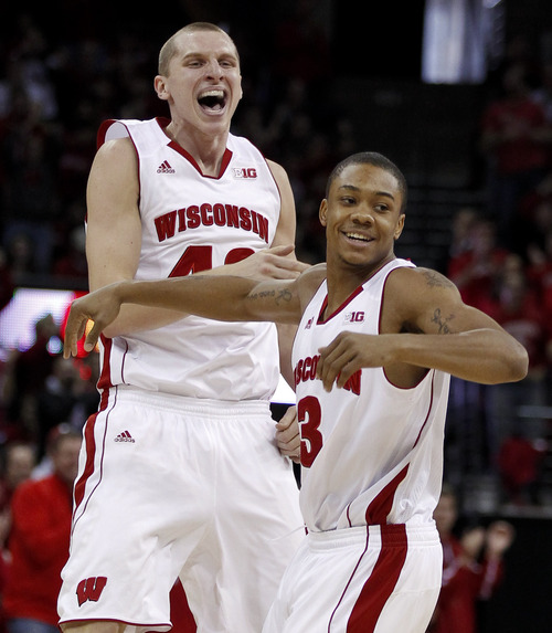 Wiscosin's Jared Berggren, left, and George Marshall celebrate a three-point basket by teammate Ben Brust during the first half of an NCAA college basketball game against Illinois, Saturday, Jan. 12, 2013, in Madison, Wis. Berggren had a team-high 15 points in Wisconsin's 74-51 upset over Illinois. (AP Photo/Andy Manis)