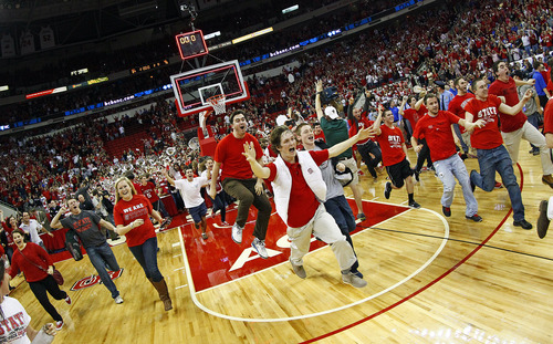 North Carolina State fans rush the court following the Wolfpack's  84-76 win over top-ranked Duke in Raleigh, N.C., Saturday, Jan. 12, 2013. (AP Photo/Karl B DeBlaker)