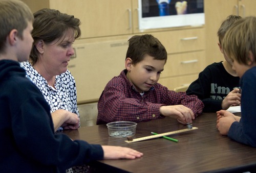 Kim Raff | The Salt Lake Tribune 
Science teacher Ruth Li watches as Isaac Oviedo, center, conducts an experament to learn about levers during a science lab at Indian Hills Elementary in Salt Lake City. The school earned a science grant for their hands-on learning lab.