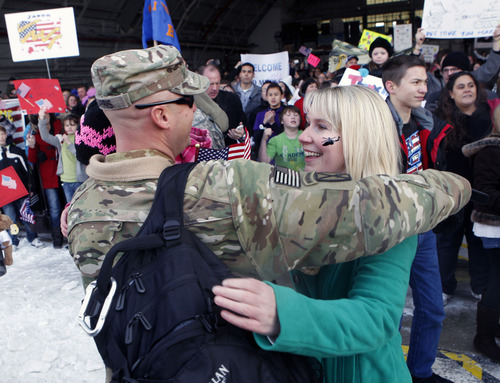Al Hartmann  |  The Salt Lake Tribune
Travis Harris of the 1st Battalion, 211th Aviation hugs his wife, Jodie, inside the Utah Air National Guard Base hangar Thursday as 150 members returned from their 12-month deployment to Afghanistan.