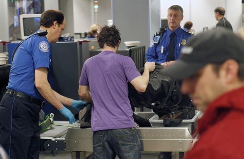 Al Hartmann  |  The Salt Lake Tribune
TSA agents helps fliers keep moving along to get personal belonging onto conveyor belt for X-ray scanning  at Salt Lake City International Airport, Terminal 2, security checkpoint Tuesday January 15 at 7:30 a.m.