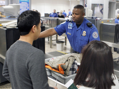 Al Hartmann  |  The Salt Lake Tribune
TSA agent helps fliers get personal belonging onto conveyor belt for X-ray scanning  at Salt Lake City International Airport, Terminal 2, security checkpoint Tuesday January 15 at 7:30 a.m.