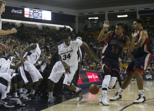 Chris Detrick  |  The Salt Lake Tribune
Utah State Aggies forward Kyisean Reed (34) tries to throw the ball off of St. Mary's Gaels guard Stephen Holt (14) while running out of bounds during the second half of the game at Dee Glen Smith Spectrum Thursday November 15, 2012. St. Mary's won the game 67-58.