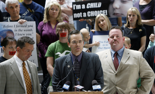Salt Lake City - (left to right bottom) Stephen Sandstom, representative from district 58, Ken Sumsion, representative district 56, and Carl Wimmer, representative from district 52, are surrounded by pro-choice and pro-life supporters as they hold a press conference at the State Capitol Rotunda Sept. 30, 2008 announcing new strict anti-abortion legislation that they will be pushing in January. Steve Griffin/The Salt Lake Tribune 9/30/08