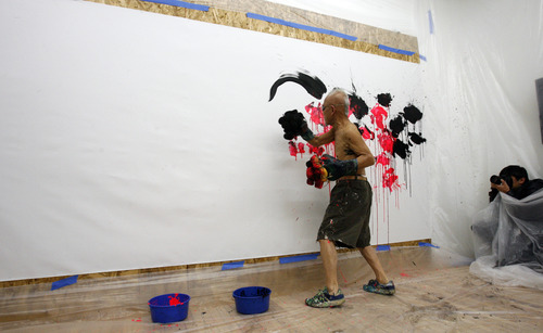 Rick Egan  | The Salt Lake Tribune 

81-year-old old Japanese artist, Ushio Shinohara, punches his art on to the canvas, with boxing gloves covered in sponges, at the Central Utah Art Center, Monday, January 21, 2013. Shinohara, is featured in the Sundance documentary film "Cutie and the Boxer."
