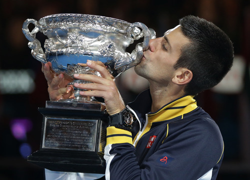 Serbia's Novak Djokovic kisses his trophy after defeating Britain's Andy Murray in the men's final at the Australian Open tennis championship in Melbourne, Australia, Sunday, Jan. 27, 2013. (AP Photo/Dita Alangkara)
