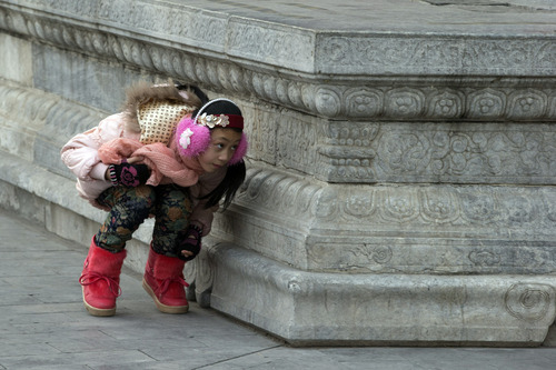 A Chinese girl plays hide and seek with her friends, unseen, at the Forbidden City in Beijing, China, Sunday, Jan. 27, 2013. (AP Photo/Ng Han Guan)