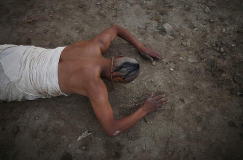 A Nepalese Hindu devotee prostrates himself on the ground outside a temple as a part of performing a ritual on the first day of Madhav Narayan festival, in Sankhu, northeast of Katmandu, Nepal, Sunday, Jan. 27, 2013. Unmarried Hindu women pray to get a good husband while the married women pray for the longevity of their husbands by observing day long fast during the month long festival. (AP Photo/Niranjan Shrestha)