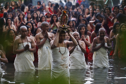 A Nepalese Hindu priest, center, carries the idol of a deity as devotees gets ready to take holy dips at the Salinadi River on the first day of Madhav Narayan festival, in Sankhu, northeast of Katmandu, Nepal, Sunday, Jan. 27, 2013. Unmarried Hindu women pray to get a good husband while the married women pray for the longevity of their husbands by observing day long fast during the month long festival. (AP Photo/Niranjan Shrestha)