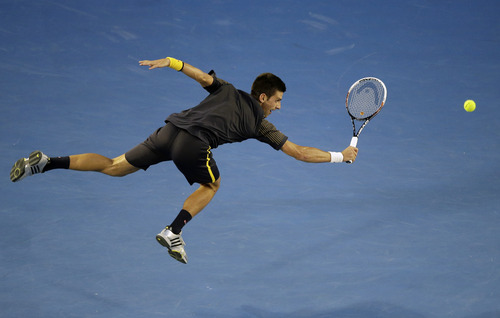 Serbia's Novak Djokovic makes a backhand return to Britain's Andy Murray during the men's final at the Australian Open tennis championship in Melbourne, Australia, Sunday, Jan. 27, 2013. (AP Photo/Rob Griffith)