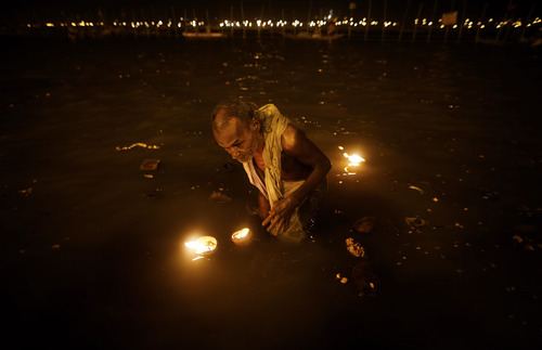 A Hindu devotee takes a holy dip at "Sangam," the meeting point of Indian holy rivers of Ganges, Yamuna and the mythical Saraswati, on occasion of "Paush Purnima," considered to be very auspicious according to Hindu calendars, during the Maha Kumbh festival in Allahabad, India, Sunday, Jan. 27, 2013. Hundreds of thousands of Hindu pilgrims are expected to take a ritual dip at Sangam on Sunday. Millions of Hindu pilgrims are likely to attend the Maha Kumbh festival, which is one of the world's largest religious gatherings that lasts 55 days and falls every 12 years. (AP Photo/Saurabh Das)