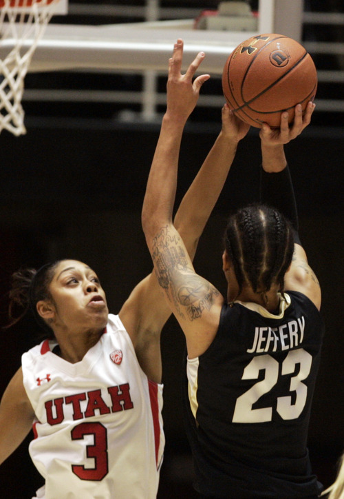 Kim Raff | The Salt Lake Tribune
University of Utah player (left) Iwalani Rodrigues gets a piece of  the ball as Colorado player Chucky Jeffrey takes a shot during a game at the Huntsman Center in Salt Lake City on January 13, 2013. Utah lost the game 43-56.